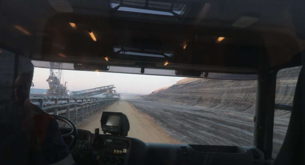 Ende Gelände. Les interpellé-es sont emmené-es à travers les chemins accidentés de la mine dans des camions-bus gigantesques conduits par des agents de la RWE. Ils et elles sont photographié-es malgré leurs peintures faciales avant d'être réexpédié-es par bus au camp de base.