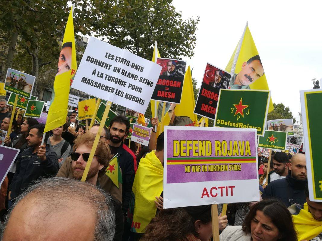 Les pancartes de soutien au Rojava côtoient celles qui dénonçent les agissements de Donald Trump et de Erdogan ( Photographie : Yoann Compagnon pour Radio Parleur)